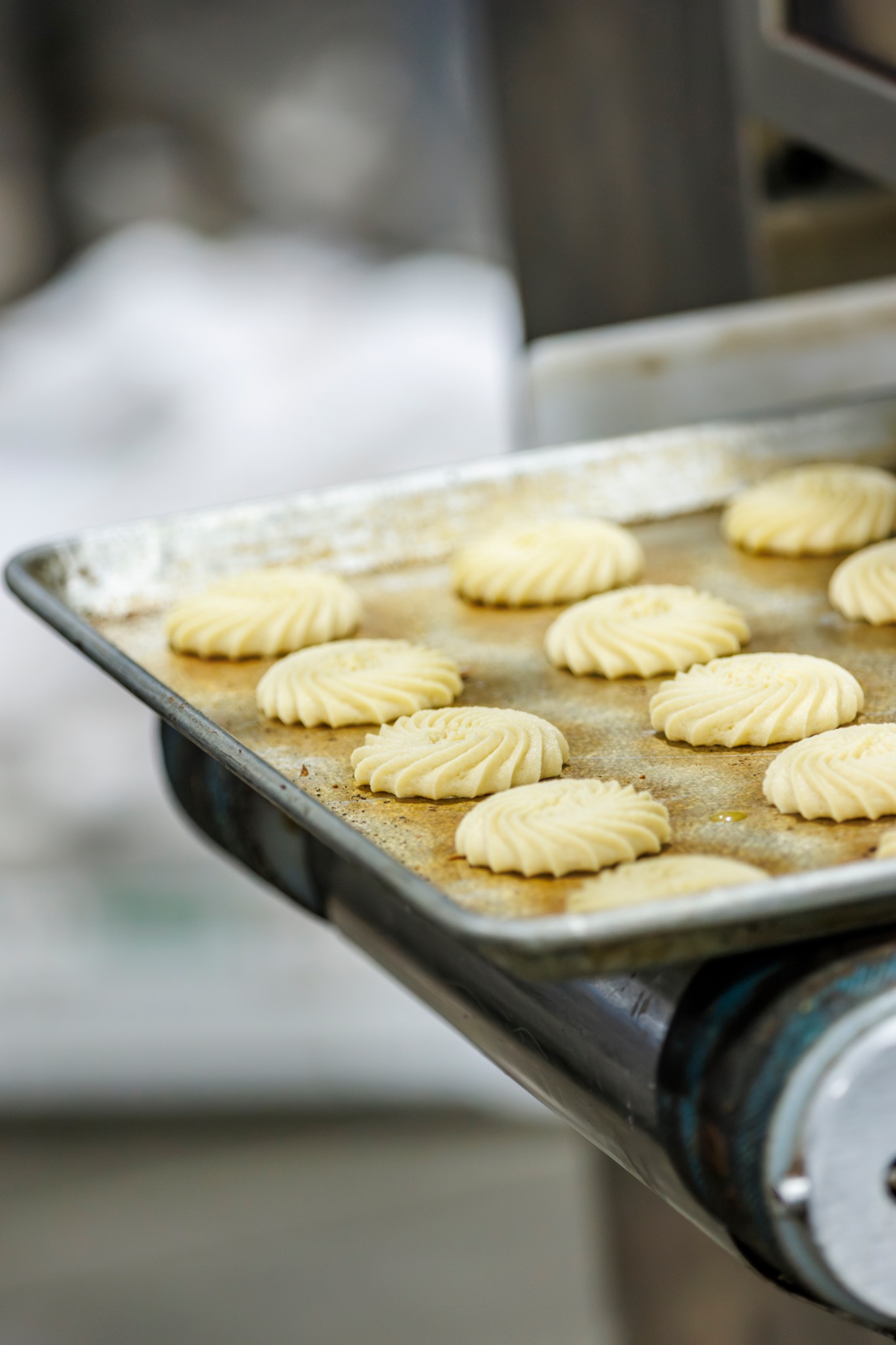Detalle de piezas de masa con forma de espiral preparadas en una bandeja