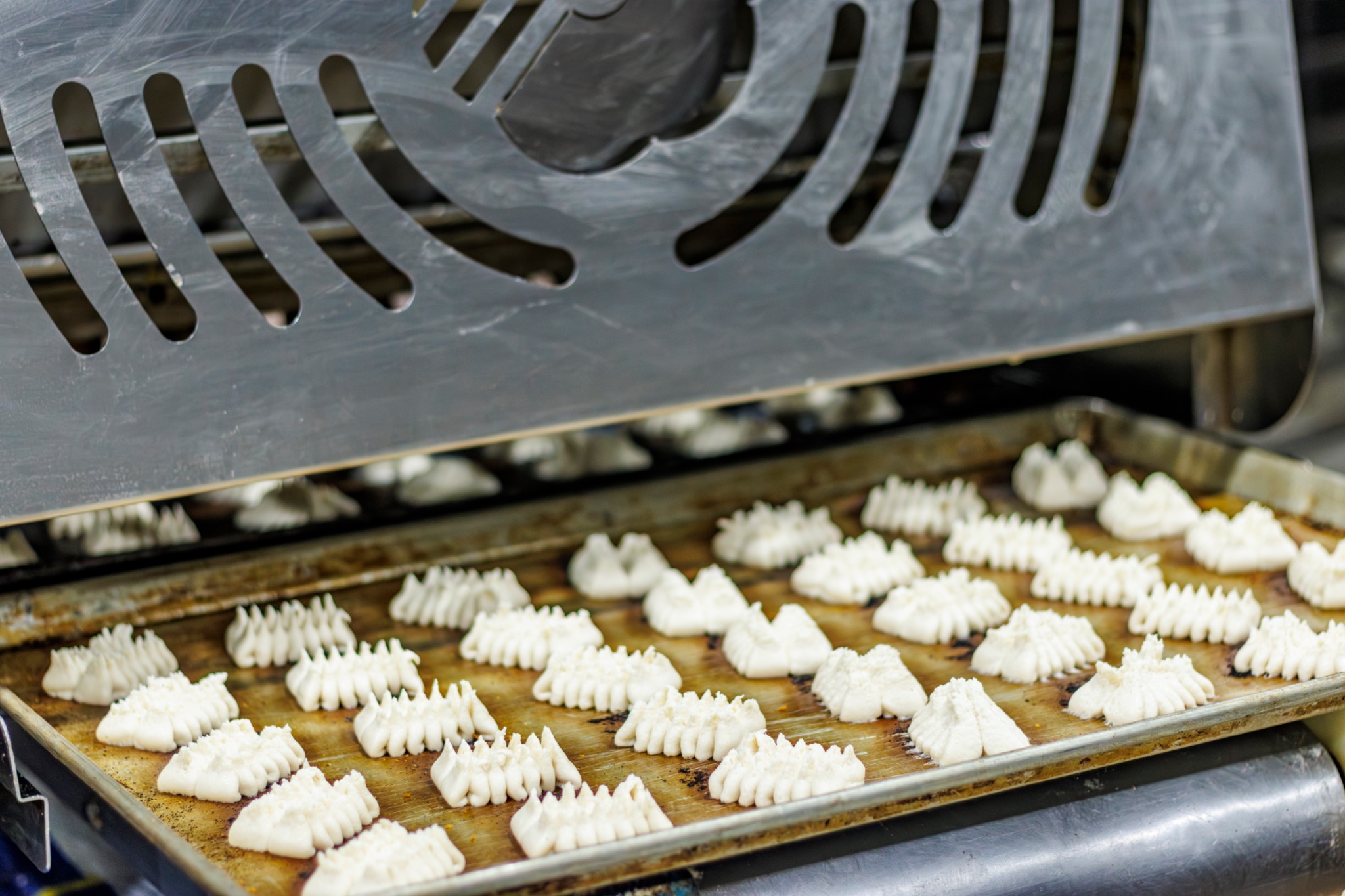 Piezas de masa con distintas formas sobre una bandeja en la máquina de producción