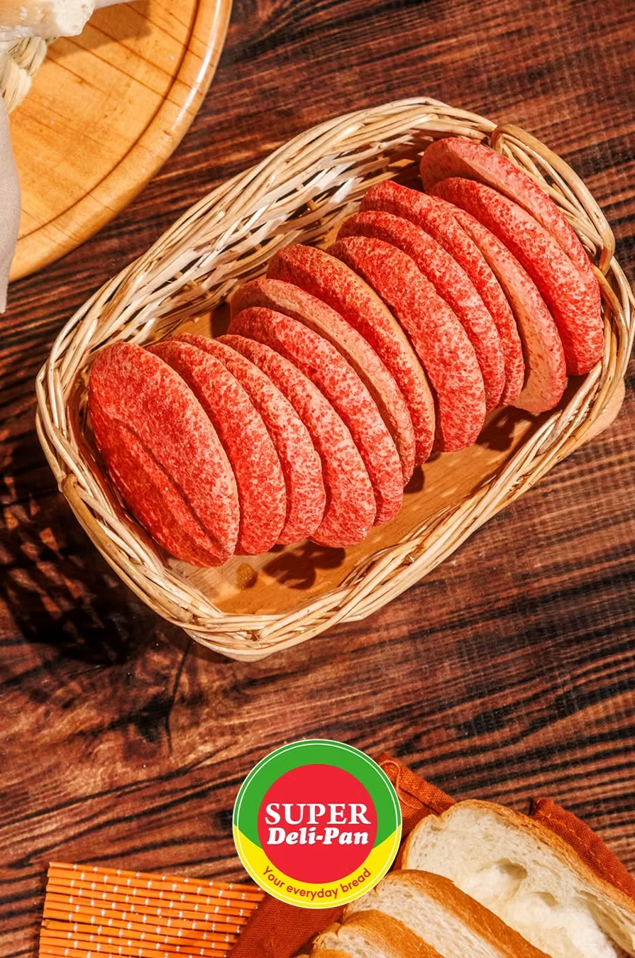 Pan dulce de cobertura roja presentado en una canasta de mimbre